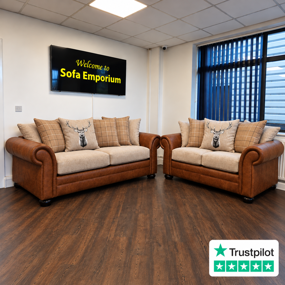 Traditional brown leather-look 3-seater and 2-seater sofas with cream fabric seats, rolled arms, tartan scatter cushions and stag-print cushions, displayed in the Sofa Emporium showroom.