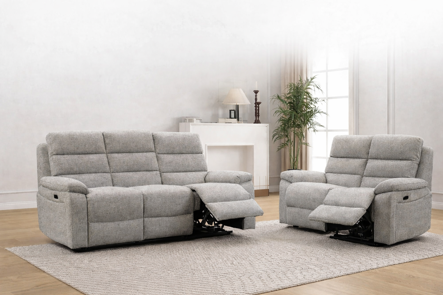 Gray reclining sofa and chair set in a living room with a white wall and wooden floor. Available to purchase at Sofa Emporium Retford.